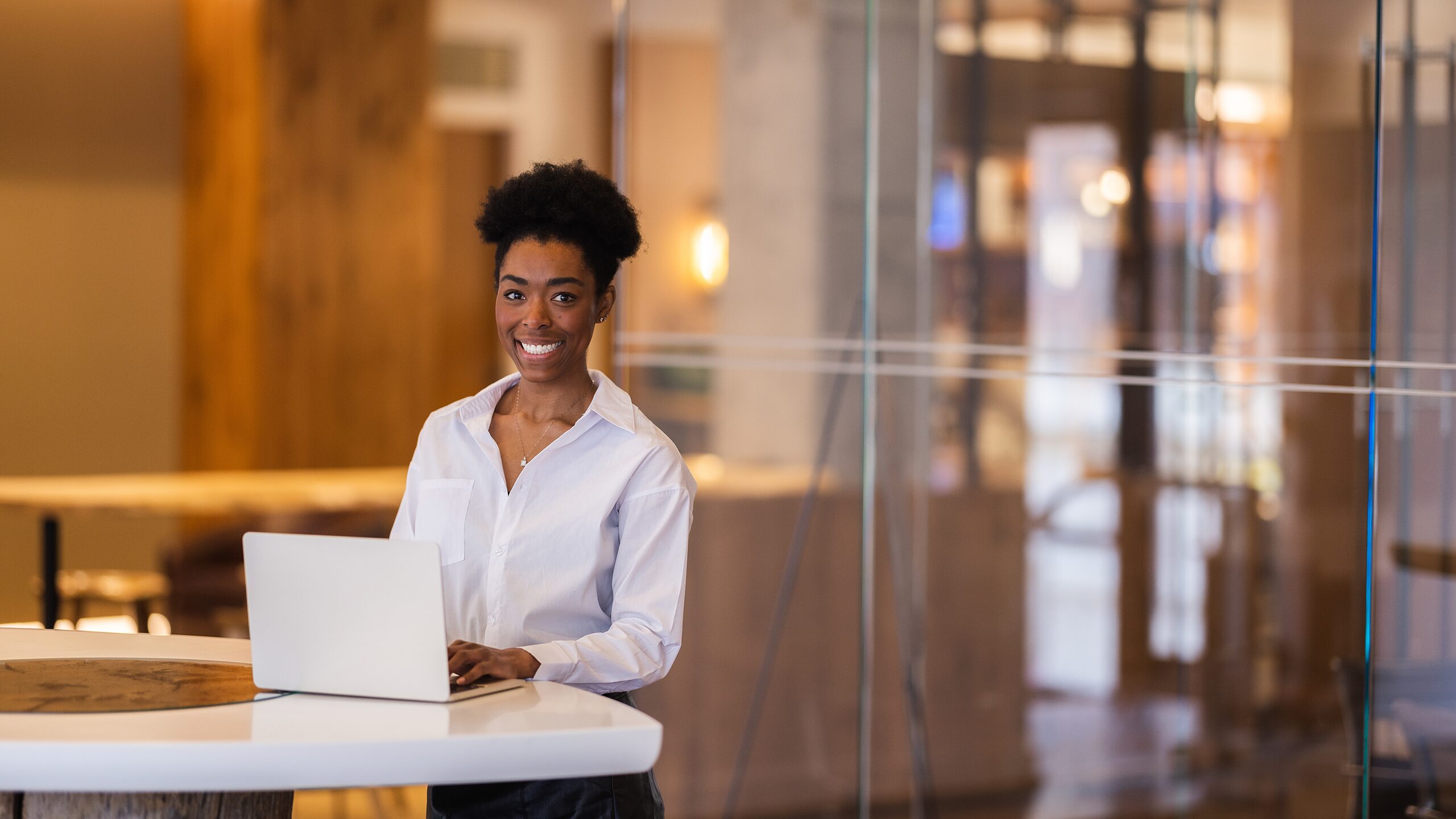 Woman works on laptop inside a conference room.